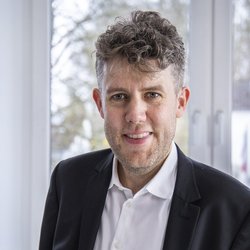 lächelnder Mann im schwarzen Anzug