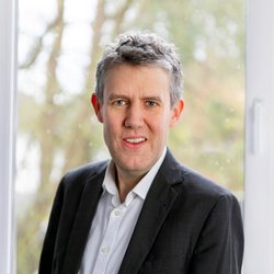 lächelnder Mann im schwarzen Anzug