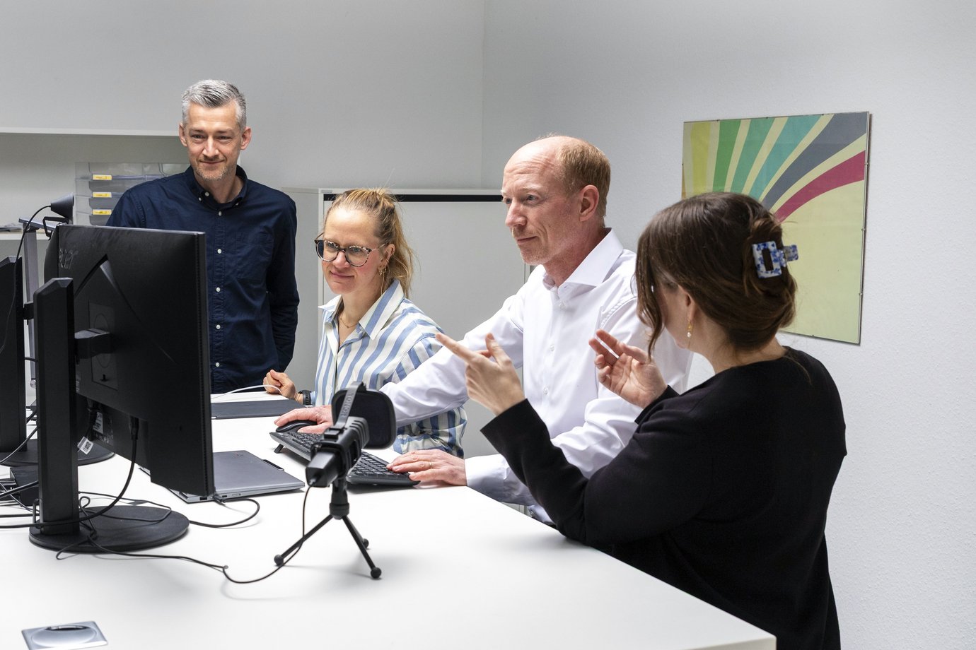 4 Mitarbeiter beraten sich mit Blick auf den PC