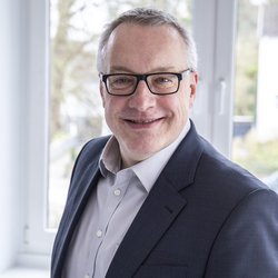 lächelnder Mann im dunkelgrauen Anzug