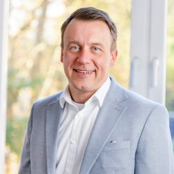 lächelnder Mann im schwarzen Hemd