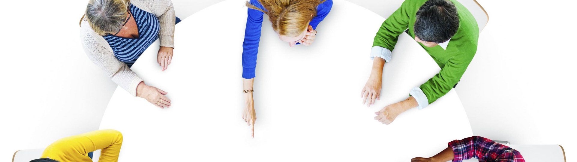 Menschen in bunten Oberteilen am Tisch aus Vogelperspektive