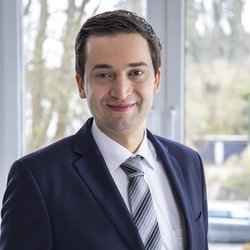 lächelnder Mann im schwarzen Anzug