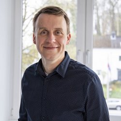 lächelnder Mann im schwarzen Hemd