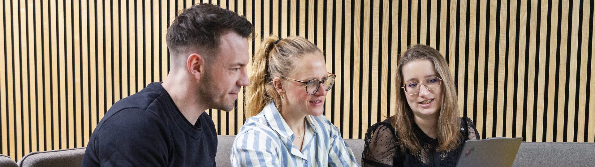 3 Mitarbeiter sprechen sich am Laptop