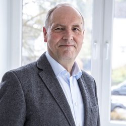 lächelnder Mann im dunkelgrauen Anzug